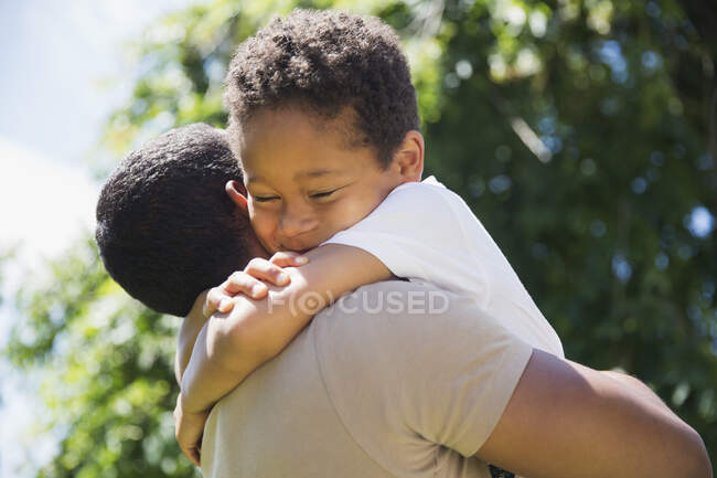 Щасливий лагідний син обіймає батька — стокове фото