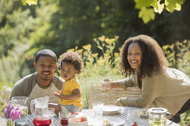 Портрет щаслива сім'я насолоджується літнім садовим обідом — стокове фото