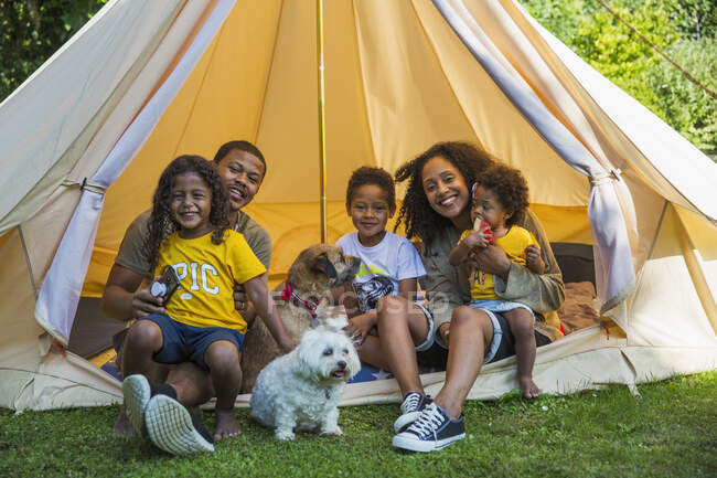 Portrait happy family with dogs in camping tent — Stock Photo
