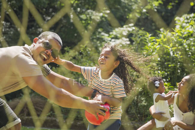 Verspielte Familie spielt Fußball im sonnigen Sommergarten — Stockfoto