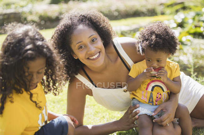Retrato feliz madre e hijos en patio de verano soleado - foto de stock