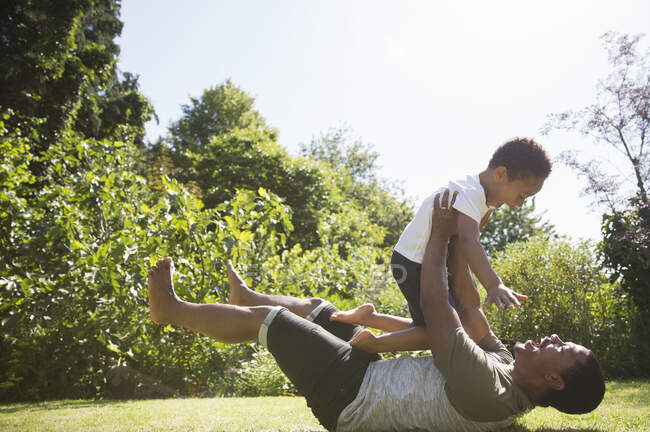 Playful father and son in sunny summer backyard — Stock Photo