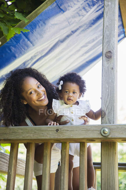 Portrait happy mother and daughter daughter on playground set — Stock Photo