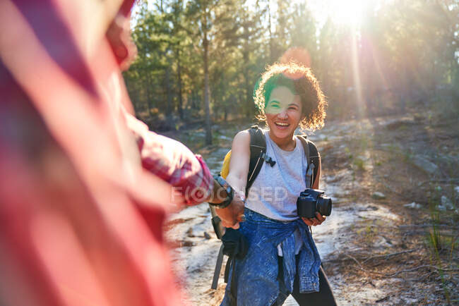 Happy young couple hiking with camera in sunny woods — Stock Photo