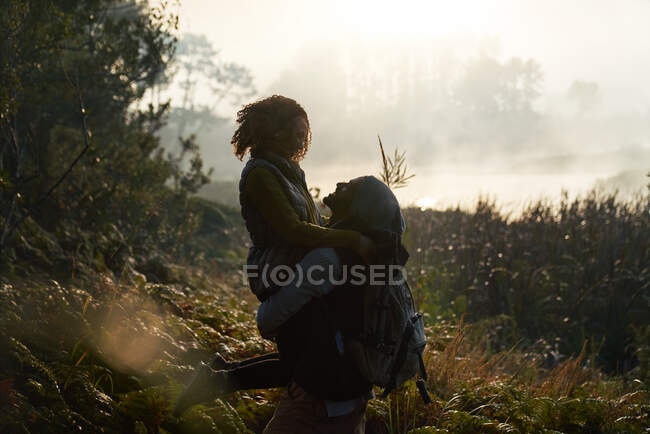 Silhouette affectionate young couple hiking in nature — Stock Photo