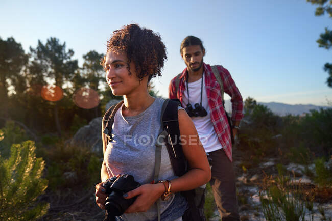 Giovane coppia escursioni con macchina fotografica e binocolo nella natura soleggiata — Foto stock