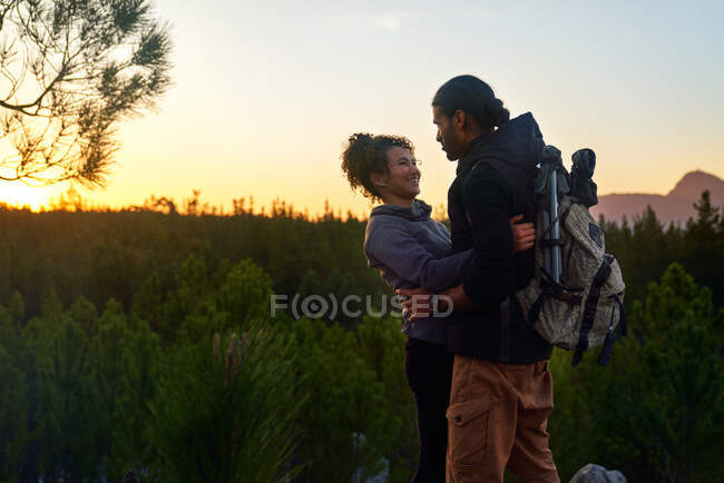 Affectueux heureux jeune couple de randonnée dans la nature au coucher du soleil — Photo de stock