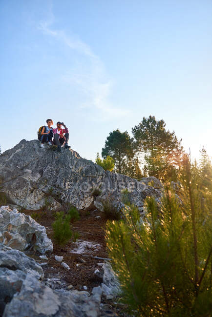 Молода пара з біноклями на скелі в природі — стокове фото