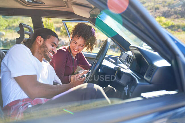 Щаслива молода пара насолоджується дорожньою подорожжю в сонячній машині — стокове фото