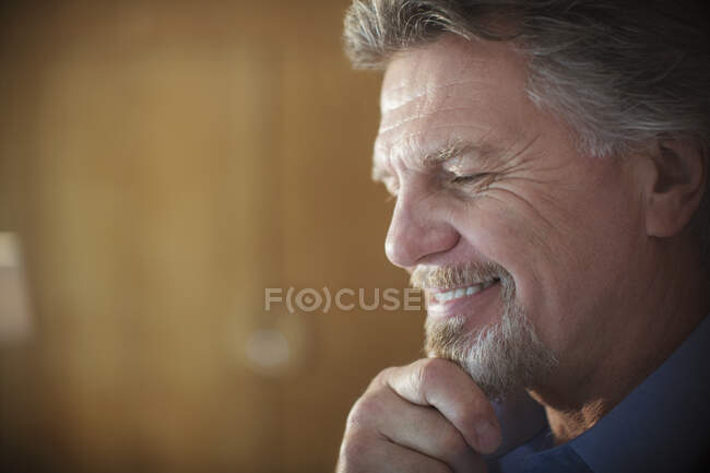 Close up uomo anziano sorridente con mano sul mento — Foto stock