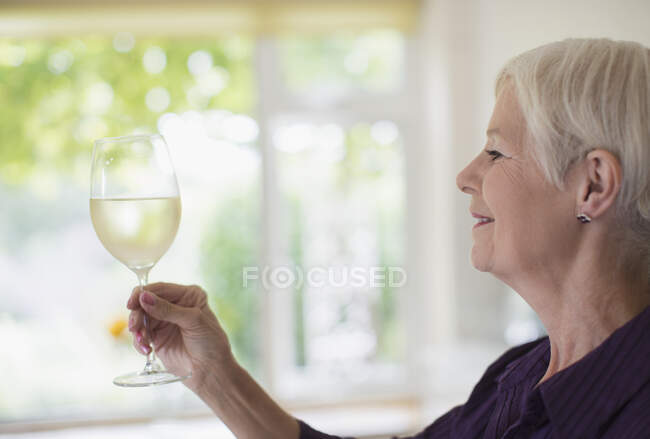 Senior mulher bebendo vinho branco — Fotografia de Stock