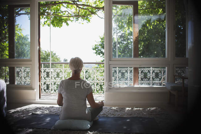 Heitere Frau meditiert am ruhigen, sonnigen Balkonfenster — Stockfoto