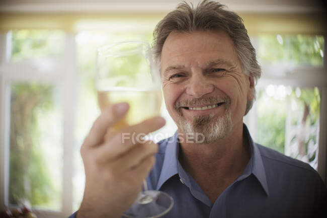 Крупним планом портрет щасливий безтурботний старший чоловік п'є біле вино — стокове фото