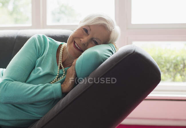 Portrait happy carefree senior woman relaxing on lounge chair — Stock Photo