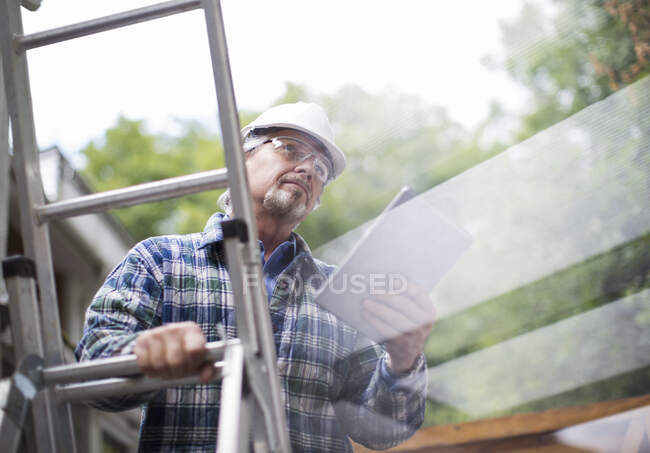Capataz de construção masculino sênior usando tablet digital na escada — Fotografia de Stock
