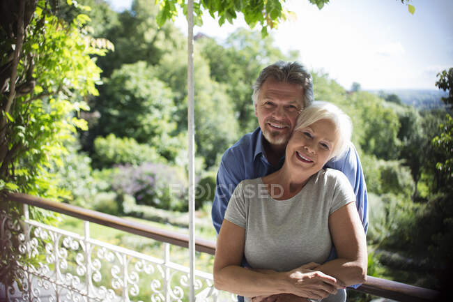 Retrato casal feliz abraçando na varanda ensolarada verão — Fotografia de Stock