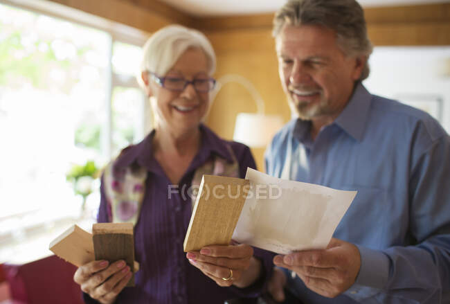 Coppia anziana guardando campioni di legno e vernice — Foto stock