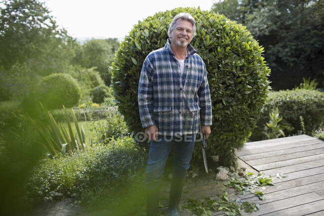 Portrait happy senior man gardening on patio — Stock Photo