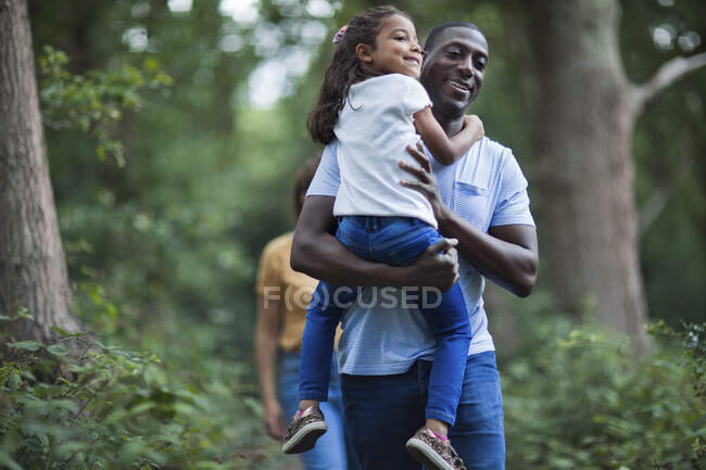 Pai feliz carregando filha em caminhada na floresta — Fotografia de Stock