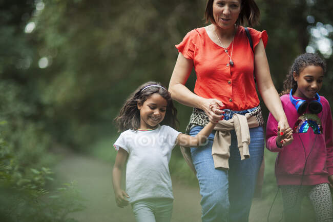 Madre e hijas haciendo senderismo en el bosque - foto de stock
