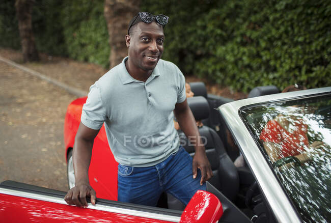Portrait handsome man getting into convertible — Stock Photo
