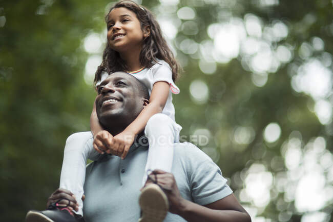 Happy father carrying daughter on shoulders — Stock Photo