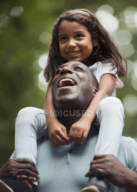 Pai feliz carregando filha em ombros — Fotografia de Stock