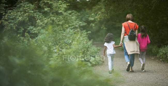 Mother and daughters hiking on path in woods — Stock Photo