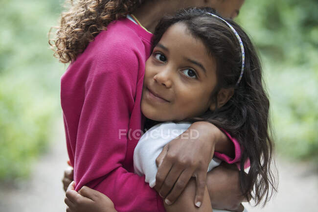 Retrato linda chica abrazando hermana - foto de stock
