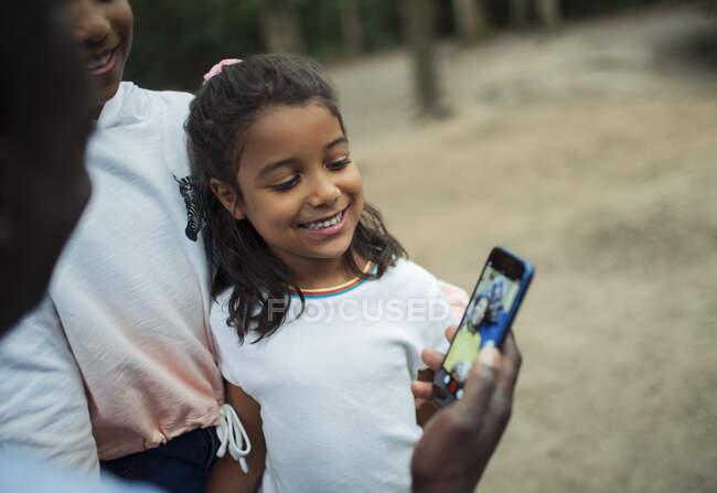 Happy family video chatting with grandparents on smart phone screen — Stock Photo