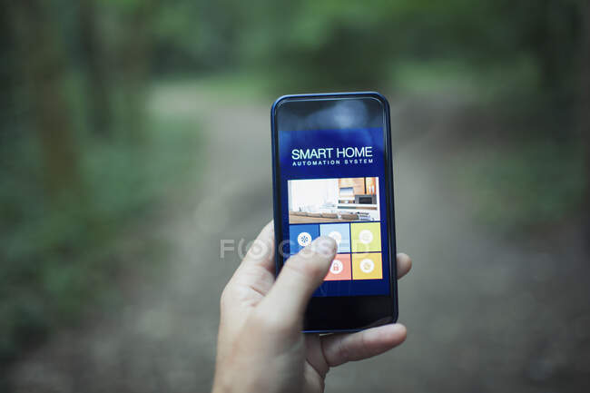 Primer plano POV aplicación de automatización del hogar en la pantalla del teléfono inteligente - foto de stock
