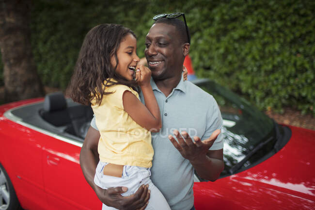 Happy father holding daughter by convertible — Stock Photo