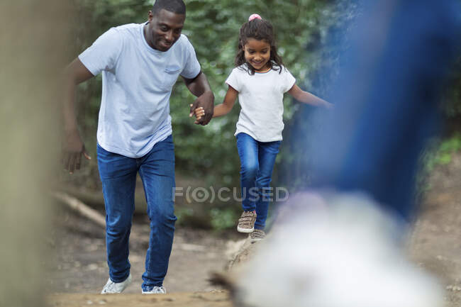 Счастливые отец и дочь бегут в лесу — стоковое фото