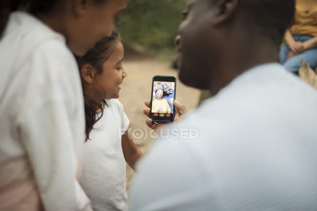Família vídeo conversando com os avós na tela do telefone inteligente — Fotografia de Stock