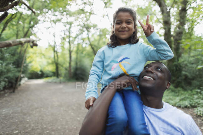 Отец-портретист с дочерью, жест мира знак в лесу — стоковое фото