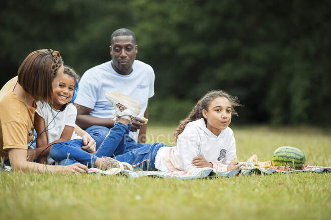 Familia relajante y disfrutando de un picnic en el parque - foto de stock