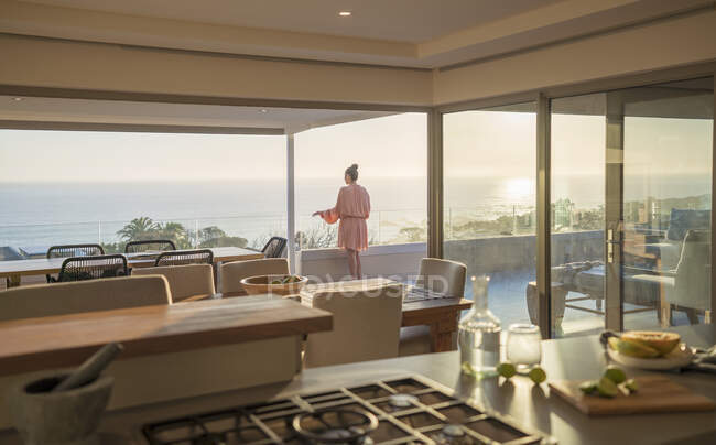 Woman in bathrobe relaxing on sunny luxury balcony with ocean view — Foto stock
