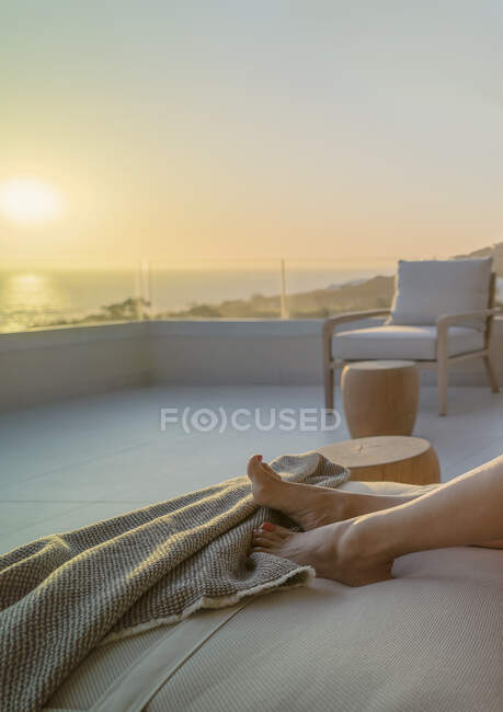 Barfüßige Frau genießt malerischen Sonnenuntergang mit Meerblick auf Luxus-Balkon — Stockfoto