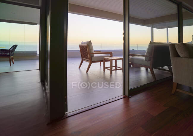 Розкішний домашній вітрина балкона з мальовничим видом на океан на заході сонця — стокове фото