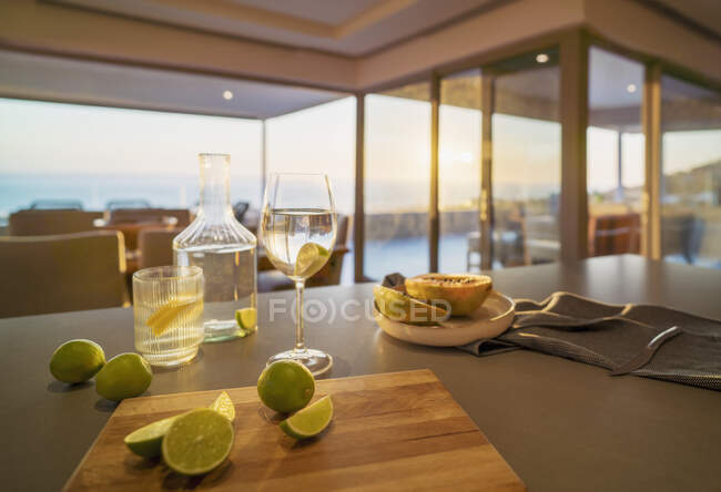 Eau et citrons verts sur le comptoir de cuisine maison vitrine de luxe — Photo de stock