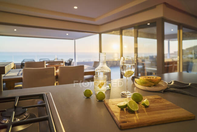 Eau et tranches de lime fraîche sur comptoir de cuisine de luxe avec vue sur l'océan — Photo de stock