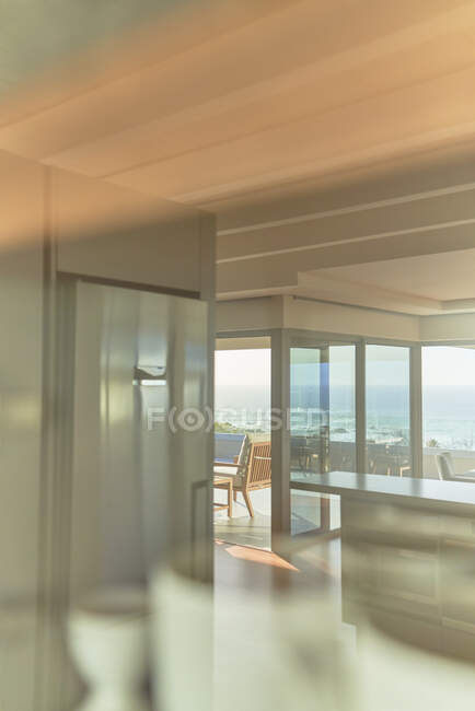 Intérieur de la maison vitrine avec vue sur l'océan ensoleillé — Photo de stock