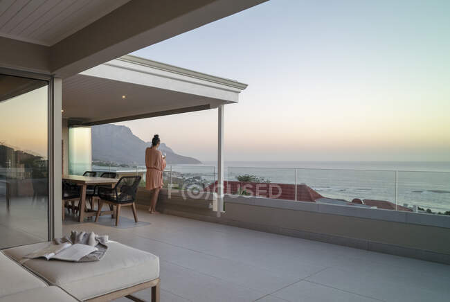 Woman enjoying wine and scenic ocean view from luxury balcony — Fotografia de Stock
