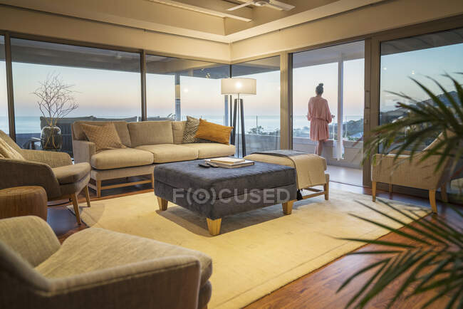 Femme profitant d'un coucher de soleil pittoresque vue sur l'océan sur balcon de luxe — Photo de stock