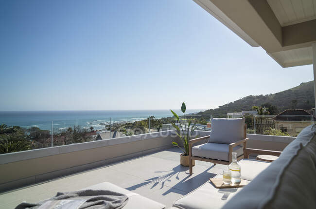 Vista panorámica soleada del océano desde el balcón del escaparate del hogar de lujo - foto de stock