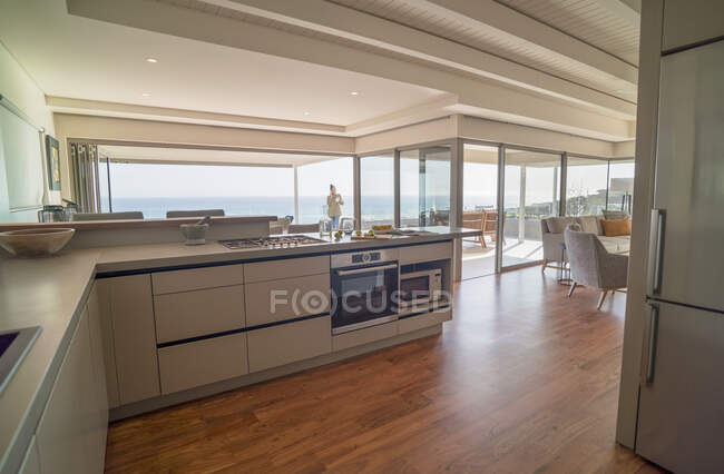 Moderna casa vetrina cucina interna con soleggiata vista sull'oceano — Foto stock