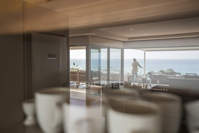 Reflexion der Frau auf sonnigem Luxus-Balkon mit Meerblick — Stockfoto