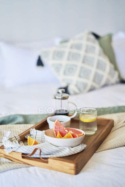 Toranja e bandeja de café da manhã na cama da manhã — Fotografia de Stock