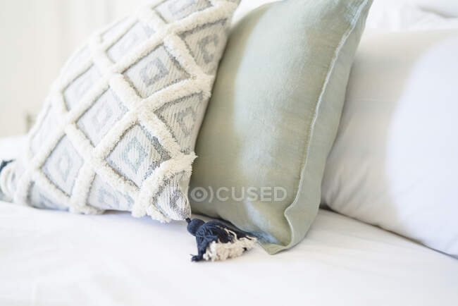 Закрыть декоративную подушку с кисточкой на кровати — стоковое фото