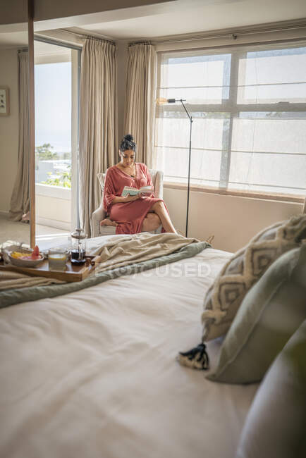 Frau entspannt mit Buch im Morgenschlafzimmer — Stockfoto